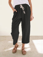 Woman wearing breezy relaxed fit straight pants in orange and black colors, showcasing supreme comfort and stylish casual look