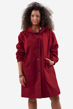Woman wearing oversized red Rain Couture Windbreaker jacket, lightweight and water-resistant with buttons and hood.