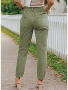 woman wearing casual button-down utility-chic trousers with pockets standing outdoors in urban setting