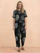 Woman wearing a relaxed 100% cotton linen set with short-sleeve top and straight-leg pants in a monochrome palette