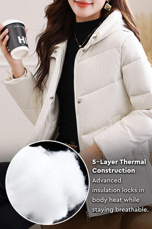 Woman wearing light beige Everyday Warmth Coat with hood and holding a coffee cup, highlighting 5-layer thermal insulation detail