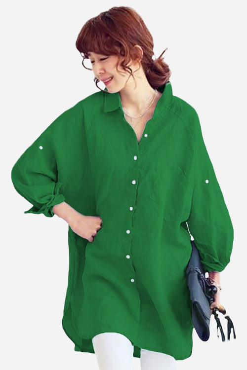 Woman wearing a green oversized linen shirt with loose sleeves and button details, styled casually.