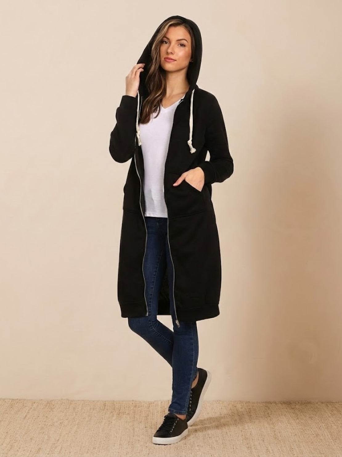 Woman wearing black oversized long zip sweatshirt hoodie with front pockets and hood