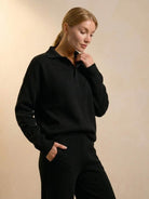 woman wearing black plush preppy two-piece travel set with polo collar and wide-leg pants