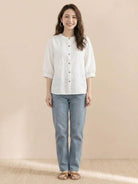 woman wearing relaxed loose breathable linen white blouse with blue jeans