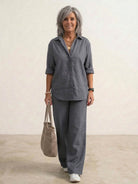 Woman wearing a monochrome relaxed shirt and trousers two-piece set standing outdoors