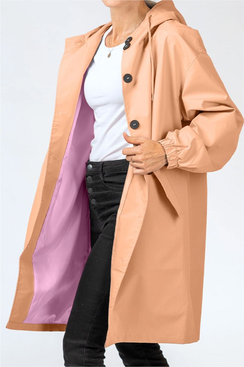 Trendy oversized Rain Couture Windbreaker in beige with lavender lining, lightweight water-resistant fabric, adjustable hood, and button closure.