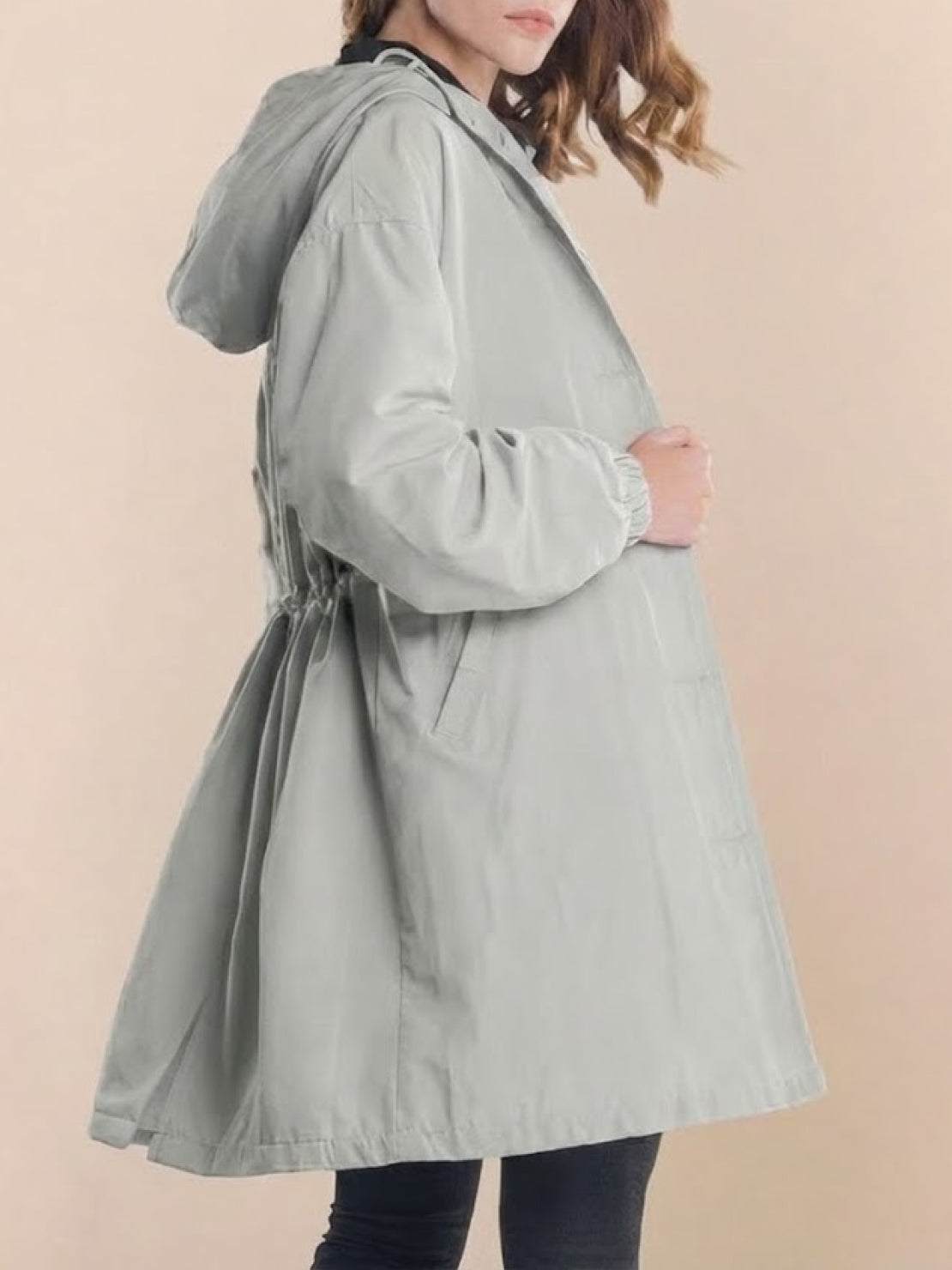 Woman wearing oversized Rain Couture Windbreaker in light grey, water-resistant with hood and adjustable waist