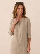 Woman wearing timeless class cotton dress in khaki with rolled 3/4 sleeves and front buttons