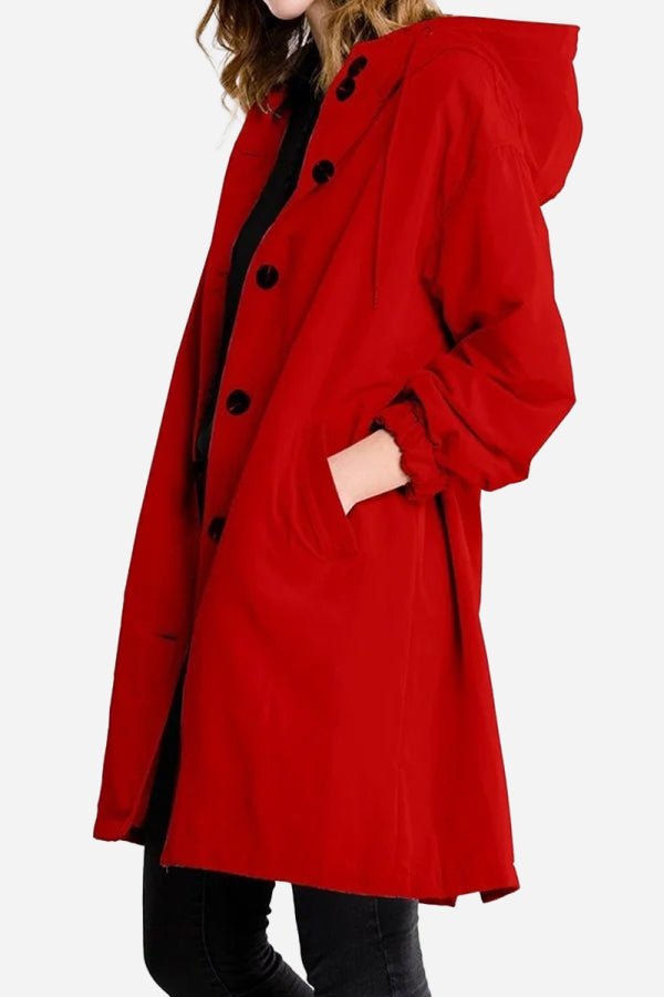 Red oversized Rain Couture Windbreaker with hood and black button closure on model