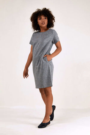 Woman wearing grey short sleeve shift dress with side pockets and round neck
